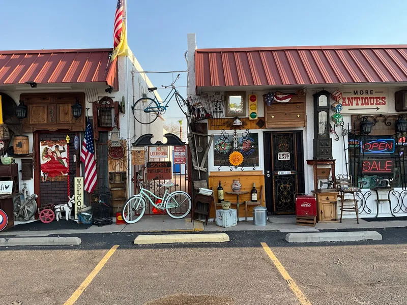 The front of Sample Studios on Apache Trail, with bicycles, signs, a Coca-Cola cooler and antiques set out along the walk