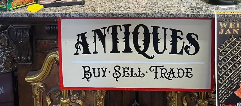 The Antiques, Buy, Sell, Trade sign on the counter at Sample Studios